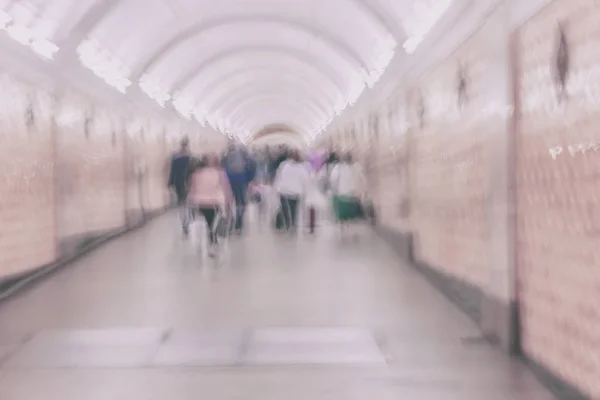 Onherkenbaar groep mensen in de bandbreedte van de gebogen. Wazig abstracte achtergrond, lichte tinten — Stockfoto