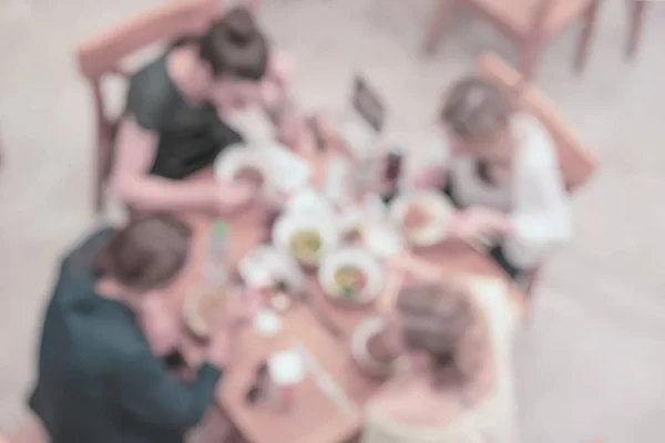 Mesa con cuatro clientes, comida rápida, patio de comidas, vista superior. Fondo de luz desenfocado borroso abstracto — Foto de Stock