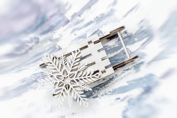 Résumé flou fond de Noël festif. Décoration en bois, flocons de neige sur petit traîneau en bois — Photo