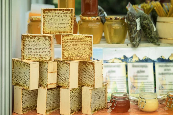 Honiggläser, Honig in Waben, Honigproduktion auf dem Bauernmarkt, echte Szene auf dem Lebensmittelmarkt — Stockfoto