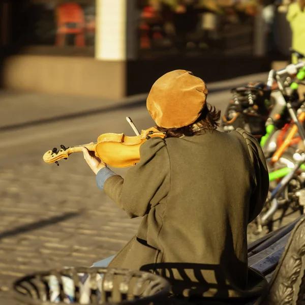 Músico de rua, uma mulher idosa irreconhecível das costas com violino nas ruas de outono da cidade, performances reais na cidade, ao ar livre, fora — Fotografia de Stock