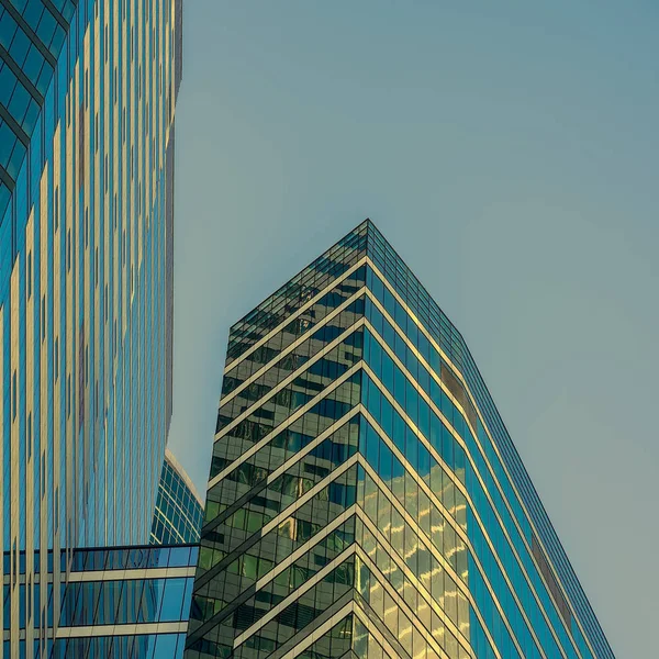 Modern abstract buildings, geometric pattern of glass and concrete, design with reflection. Urban building background