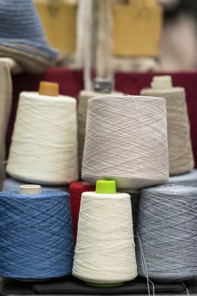 Varios hilos multicolores coloridos en carretes cinta métrica. Industria de hilos textiles, industria de la confección — Foto de Stock