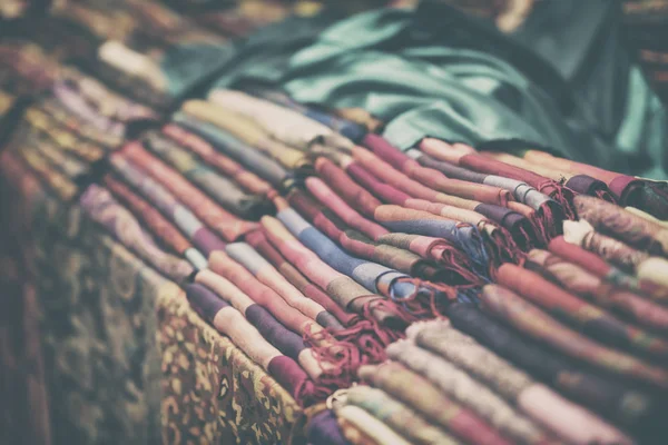 Bufandas de tela multicolor, chales, estolas, estante de la tienda real, fondo vintage — Foto de Stock
