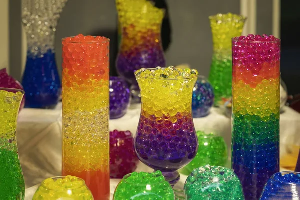Mehrere Glasvasen mit absorbierenden Hydrogelkugeln, helle Farben — Stockfoto
