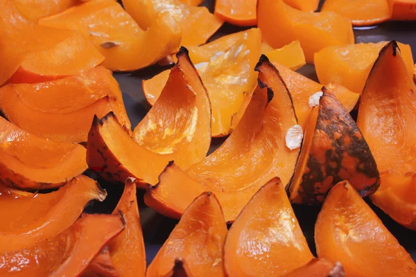 Домашние запеченные кусочки ярко-оранжевого цвета тыквы на листе выпечки — стоковое фото