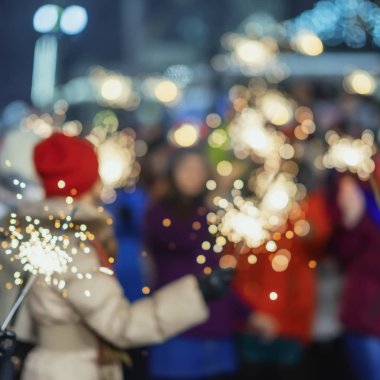 Tanınmayan gençlerle bengal ışıklar gece, mutlu Noel partisinde. Parlak Festival arka plan, kopya alanı bulanık. Kış tatili, mutlu yeni yıl