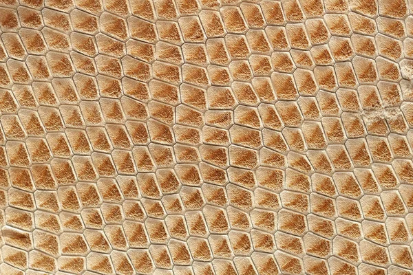 Genuine leather texture with embossed scales of exotic reptile, light orange brown surface, trendy background