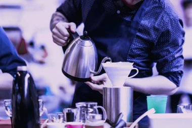 Profesyonel barista apronda özel su ısıtıcısı kaynar su filtresi, filtre kahve hazırlanması dökme. Mor renk arka plan