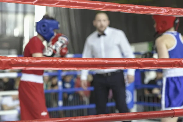 Blurred image young athletes boxers and sports referee in a ring boxing game