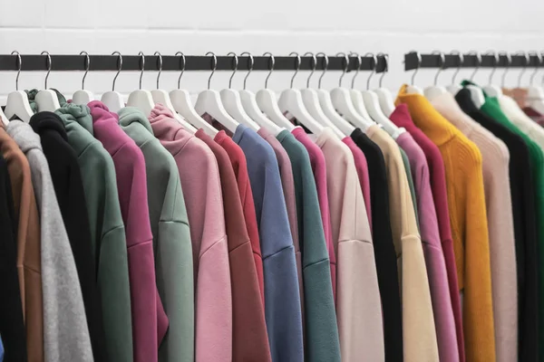 Felpe giovani colorate e maglioni di cashmere su un portabiti — Foto Stock