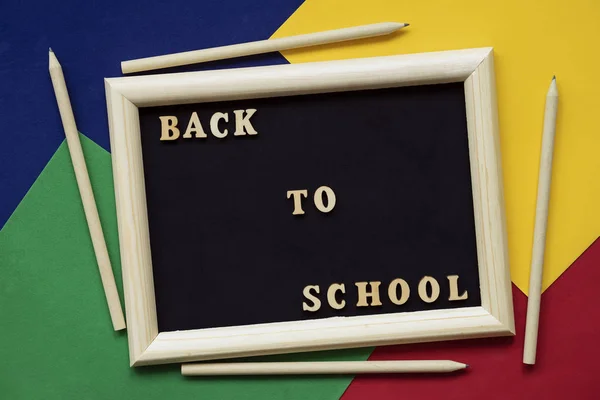 Volver a la escuela texto y lápices de madera en pizarra negra en marco de madera. Concepto de educación, inicio de la escuela. Fondo colorido — Foto de Stock