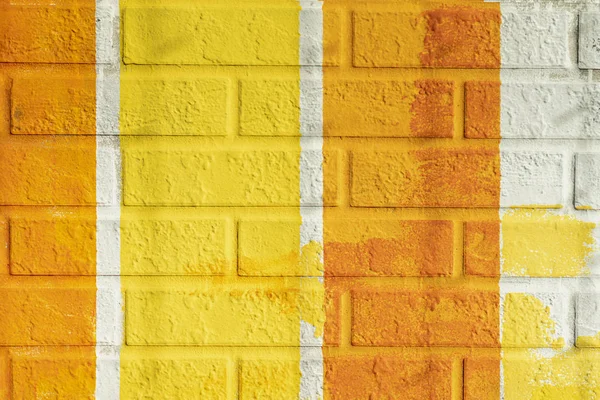 Cihlový povrch stěn, namalovaný proužkovaný v zářivě oranžových a žlutých barvách. Grafická textura barevné stěny, pro pozadí — Stock fotografie
