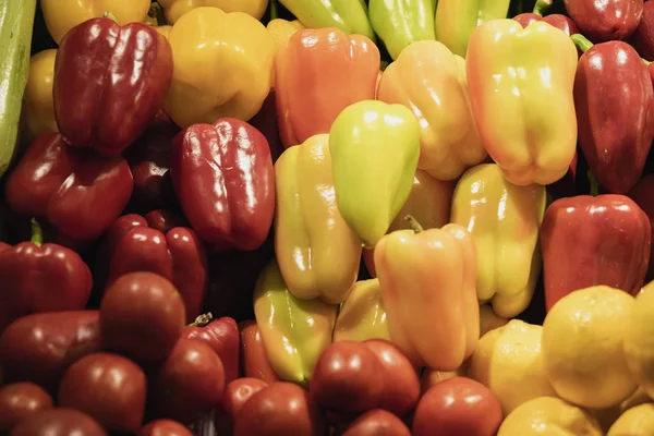 Natural vegetable background from colorful fresh organic sweet bell peppers. Farmers market counter, vegetables closeup, heap of live vitamins