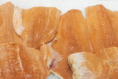 Somon filetosu süpermarkette buzda yakın plan porsiyonlara. Deniz ürünleri ve balık satışı. Açık vitrinler, deniz ürünleri pazarının tezgahı.