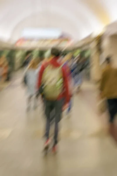 Abstrato imagem borrada cara jovem irreconhecível com uma mochila, grupo de pessoas no corredor arqueado — Fotografia de Stock