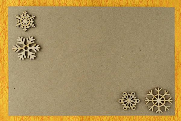 Fondo de Navidad natural abstracto, textura de papel de cartón con copos de nieve de madera en marco estampado. Fondo vintage, espacio para copiar —  Fotos de Stock