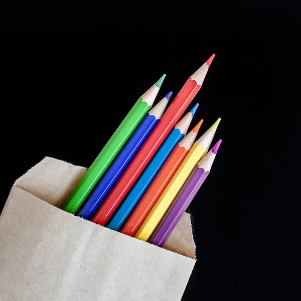 Set Van Gekleurde Potloden Een Ambachtelijke Papieren Zak Een Zwarte — Stockfoto