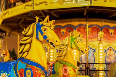 Parlak renkli atları olan renkli bir panayır atlıkarınca. Yakın çekim, tatil, Noel pazarı, seçici odaklanma.