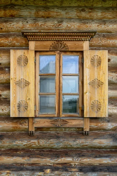 Ventana de madera natural con persianas, decorada con patrones tallados, antigua casa de pueblo —  Fotos de Stock