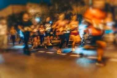 Sokakta koşan büyük bir grup sporcu, gece maratonu, bulanık etki, tanınmayan insanlar. Spor, spor, sağlıklı yaşam tarzı konsepti. Soyut arkaplan