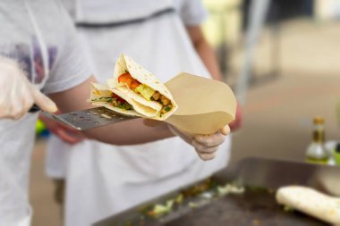 Ellerim sağlıklı fajita ya da fajitoları peynir, biftek, domates ve ızgarayla pişiriyor. Ulusal otantik gıda kavramı