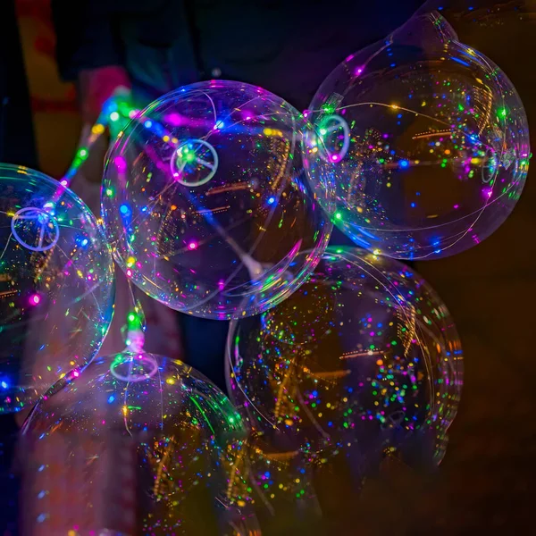 Πολύχρωμα μπαλόνια LED στο μαύρο φόντο. Πολύχρωμα ζωηρά λαμπερά φώτα bokeh τη νύχτα. — Φωτογραφία Αρχείου