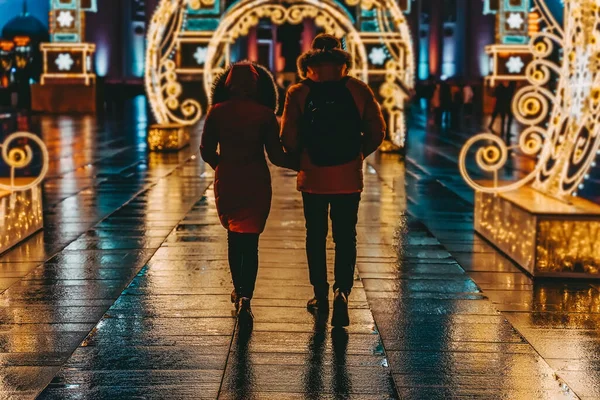 ネオンライトのアーチ お祝いの照明で街に行く2つの認識できないエナメル若者 夜遅く クリスマス ロマンチックなデートのコンセプト — ストック写真