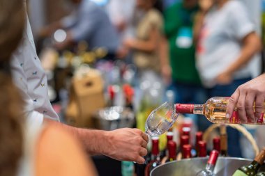 BURGAS, BULGARIA - 25 JULY, 2025: Rose wine poured into a glass during a wine tasting event in Burgas, Bulgaria. Concept of wine, alcohol culture, tasting at summer festival.