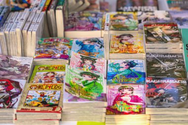 BURGAS, BULGARIA - AUGUST 01, 2025: Stacks of colorful manga books are displayed on table, featuring popular Japanese series. Concept of manga culture, Japanese storytelling, comic books