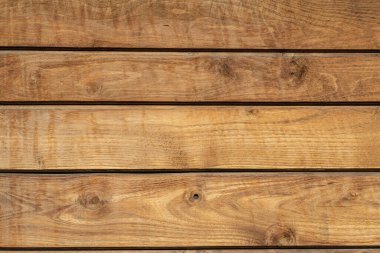 Zengin tahıl desenleri ve sıcak tonlara sahip doğal ahşap bir yüzeye yakından bakmak, işlenmemiş kerestelerin güzelliğini vurgulamak, arka plan, doku veya kırsal tasarım elementleri için mükemmel.