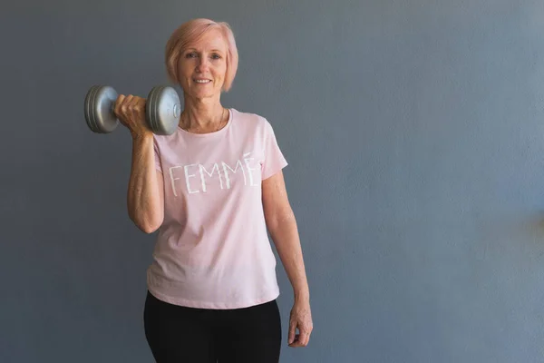 Senior woman lifting weights staying fit