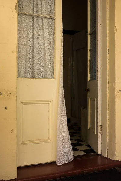 在一个古老的女王式的房子里 窗帘在敞开的古董店门口吹进了卧室 — 图库照片