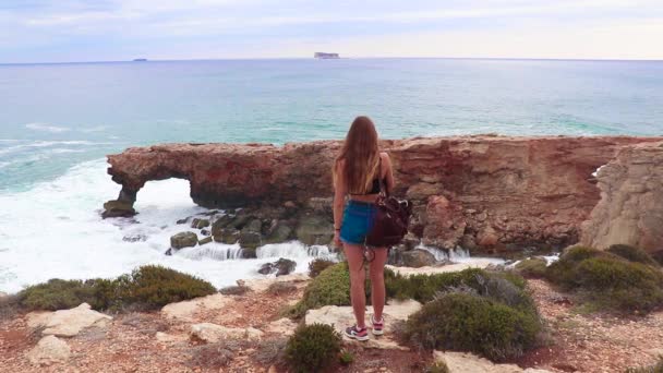 Девушка Смотрит Волны Которые Попадают Каменную Арку Красивые Природные Скальные — стоковое видео
