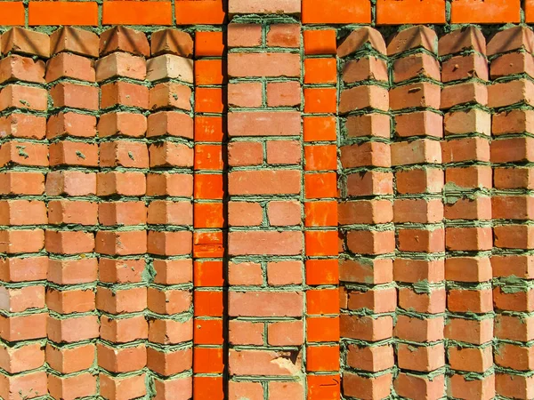 Red brick wall laid out by a snake
