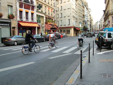 Paris, Fransa - 16 Ekim 2005: Merkezi caddelerden birinde bisikletçiler. Tipik bir şehir manzarası.