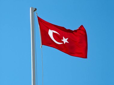 Türkiye bayrağı mavi gökyüzüne doğru dalgalanırken bayrak direğinde