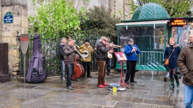 PARIS, FRANCE - 23 Mart 2014: Saint-Germain-des-Pres Manastırı 'nın duvarlarındaki sokak müzisyenleri. Bahar yağmuru, iyi ruh hali..