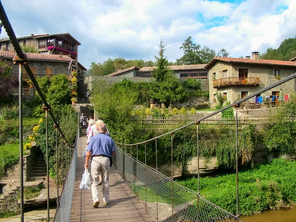 Rupit-Pruit, Katalonya, İspanya - 8 Ekim 2013: Eski kente giden küçük bir nehir üzerindeki asma ayak köprüsü - popüler bir turizm beldesi.