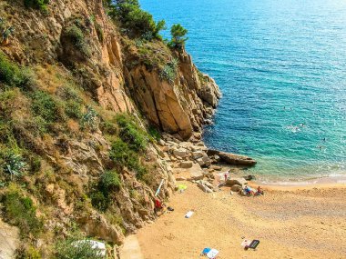 Tossa de Mar, Katalonya, İspanya - 8 Ekim 2013: Playa d 'es Codolar (plaj) antik bir kalenin duvarlarının altındaki uçurumun dibinde (Villa Vella)