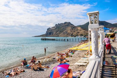 Koktebel, Kırım - 9 Eylül 2018: Karadeniz 'in arka planındaki set ve plaj ve sönmüş olan Karadağ volkanı sıradağları (Kara-Dag)