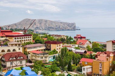 Sudak, Kırım - 6 Eylül 2018: Oteller ve emekli aylıklarıyla kentin kıyı kesiminin görüntüsü ve doğuda Alchak Dağı