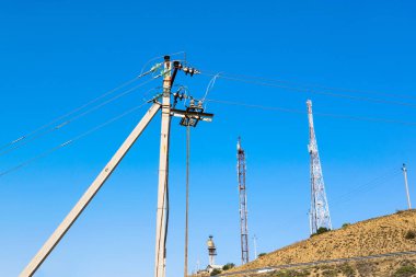 Mavi gökyüzüne karşı telekomünikasyon ve güç nakil tesisleri