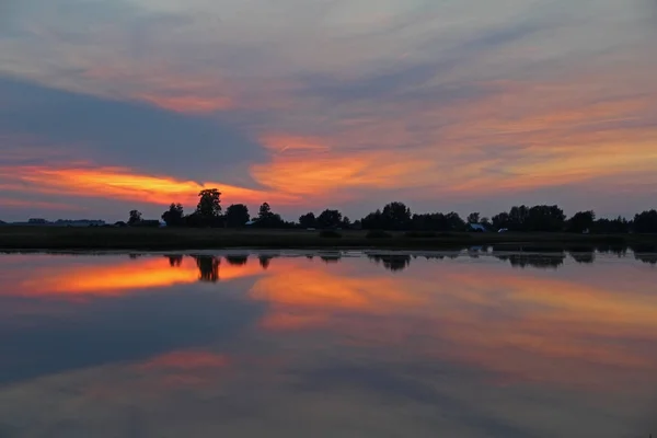 Colorful sky and colorful water in lake reflected in evening. Fantastic landscape. Russia.