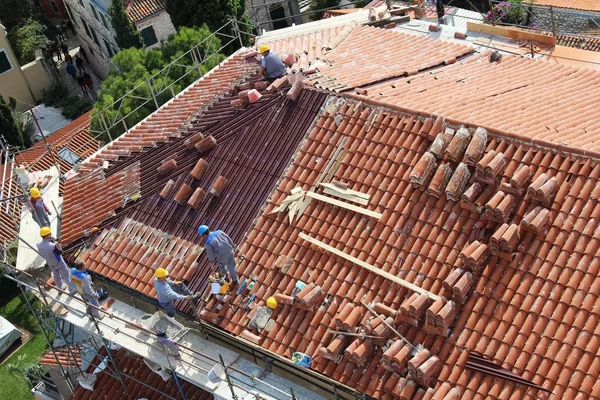 ROVINJ, CROATIA - 07 de outubro de 2019: Roofers no telhado do edifício estão colocando novas telhas. Rovinj cidade velha, Ístria, Europa. Rovinj cidade velha, Ístria, Europa . Imagem De Stock