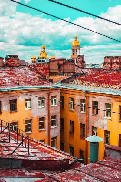 The old red Roofs of Saint-Petersburg. Panoramic View. An old yard and historical buildings. Walk on the roofs. Yellow old walls with windows. Shabby walls