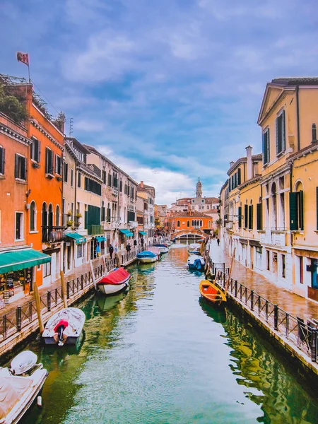 Boats on a canal in Venice. Old houses along the seafront of the Venetian canal. Travel to Italy. River, bridge, facades of houses