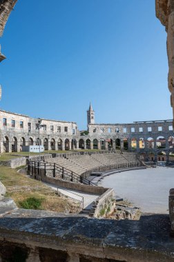 Pula Arena 'nın bir parçası, arenası ve kilise manzaralı, türünün en büyük altıncı amfitiyatrosu, Hırvatistan, Avrupa' da mavi gökyüzü