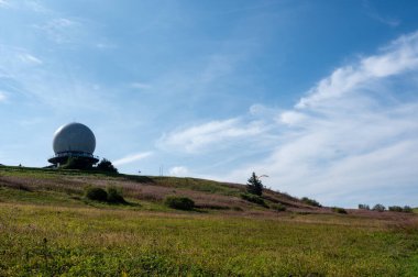 Radar kubbesi, Almanya 'nın yüksek Rhoen bölgesindeki Wasserkuppe zirvesinde, yeşil bir çayır ve pembe bir Willonerb ile, mavi gökyüzü ile güzel bir yaz günü