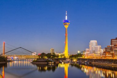 Rhein kulesi ve Düsseldorf ve Rheinknie Köprüsü'nde Medya limanı mavi saatte arka planda